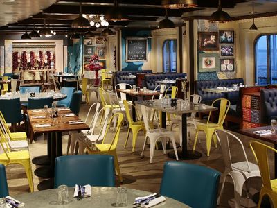 The dining room of Jamie's Italian features blue and yellow chairs, showcasing a vibrant and inviting atmosphere.